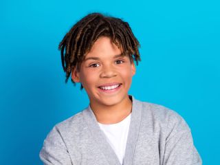 Teen young man smiling on blue background