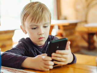 Kid playing games on smart phone | Child dental health