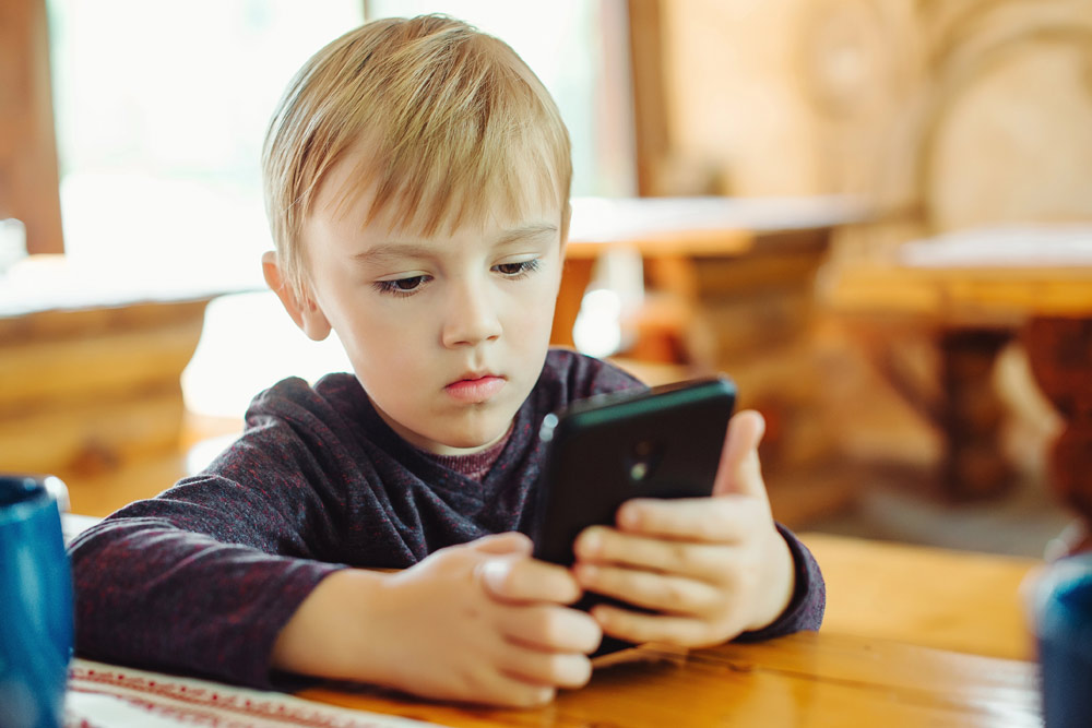 Kid playing games on smart phone | Child dental health