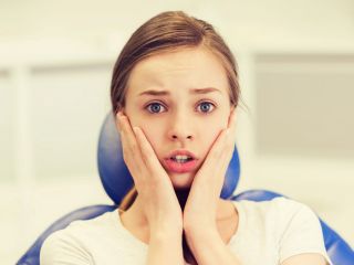 Anxious young woman at orthodontic appointment | Dental health