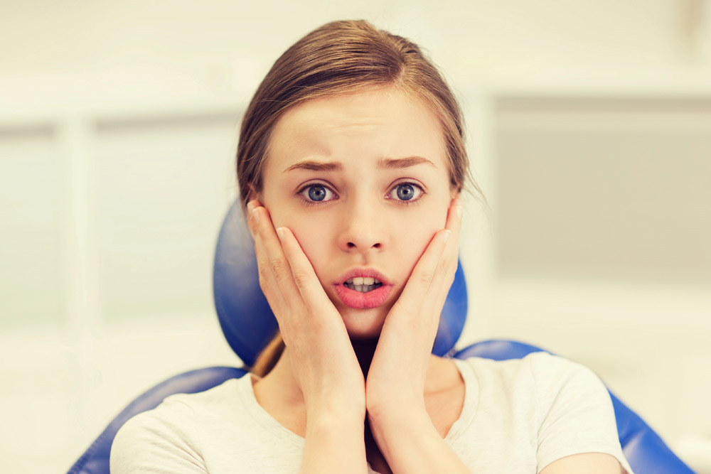 Anxious young woman at orthodontic appointment | Dental health