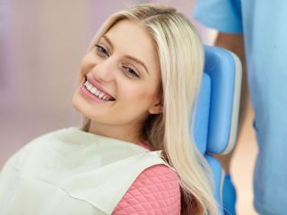 Young woman smiling at orthodontics appointment | Life after braces