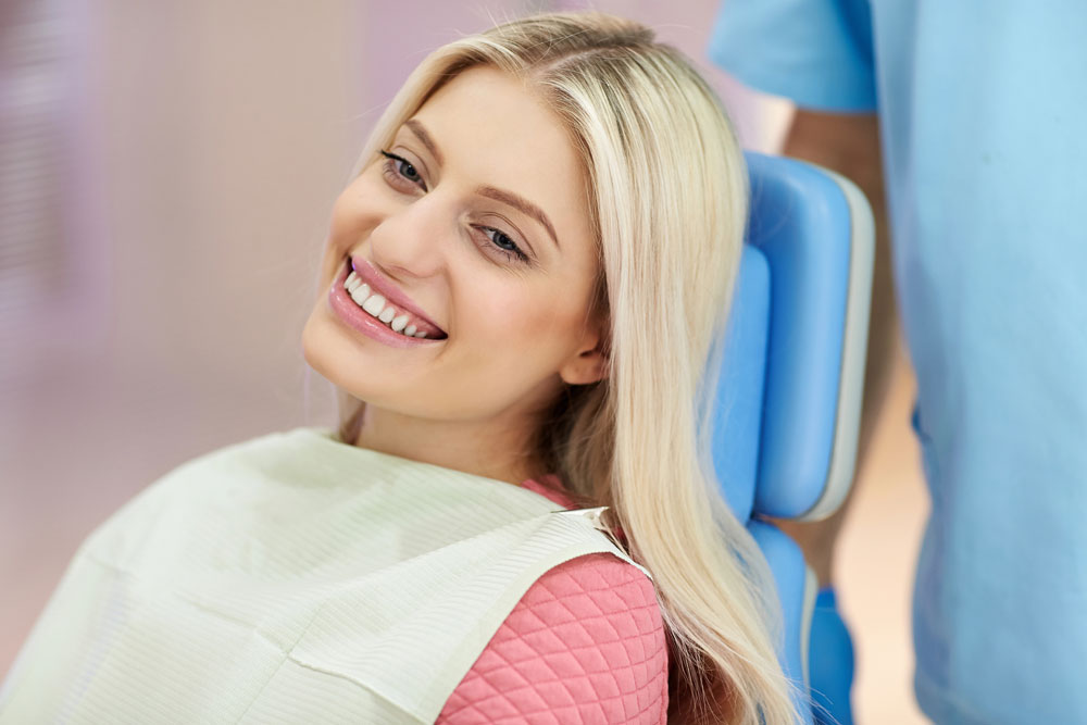 Young woman smiling at orthodontics appointment | Life after braces